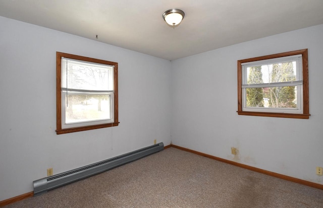 carpeted spare room with plenty of natural light and a baseboard heating unit