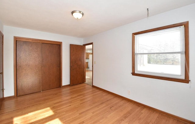 unfurnished bedroom featuring a closet and light hardwood / wood-style flooring