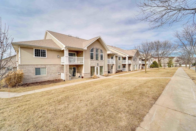 view of front of house with a balcony and a front yard