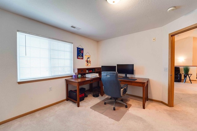 carpeted office space featuring a textured ceiling