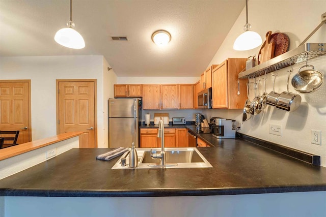 kitchen featuring appliances with stainless steel finishes, sink, kitchen peninsula, and decorative light fixtures