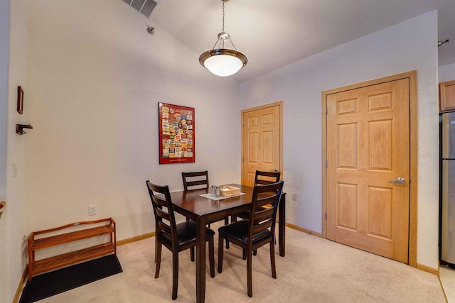 carpeted dining room with lofted ceiling