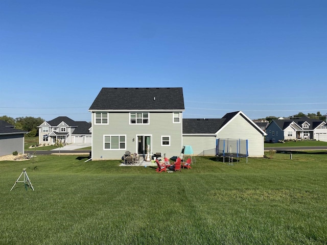 rear view of house featuring a patio, a trampoline, and a lawn