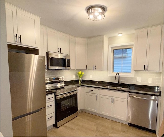 kitchen featuring white cabinetry, stainless steel appliances, sink, and decorative backsplash