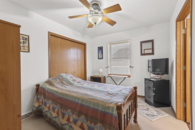 carpeted bedroom featuring ceiling fan and a closet