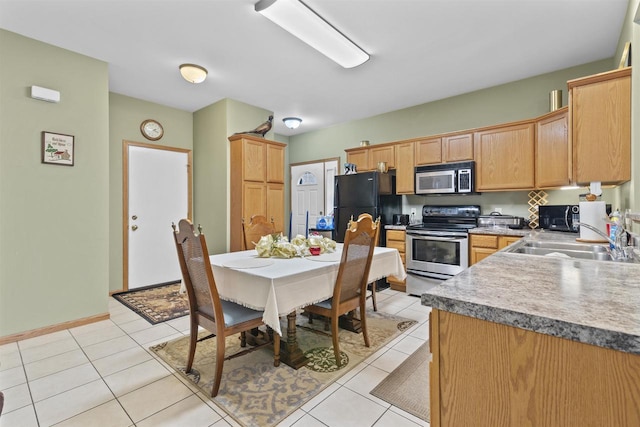 kitchen featuring light tile patterned flooring, appliances with stainless steel finishes, and sink