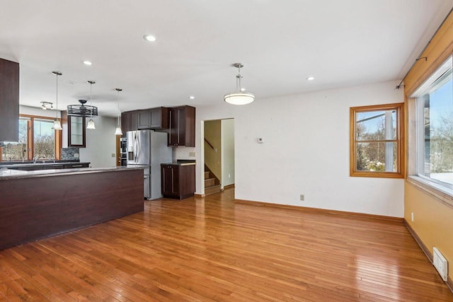 8209 N Port Washington Rd, Fox Point, WI 53217 - kitchen with light wood finished floors, baseboards, decorative light fixtures, and stainless steel fridge with ice dispenser