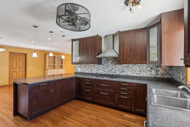 8209 N Port Washington Rd, Fox Point, WI 53217 - kitchen featuring dark countertops, glass insert cabinets, a peninsula, wall chimney range hood, and a sink