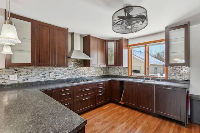 8209 N Port Washington Rd, Fox Point, WI 53217 - kitchen featuring glass insert cabinets, wall chimney range hood, stainless steel gas cooktop, pendant lighting, and a sink