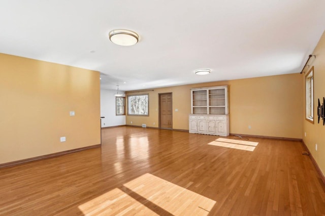 8209 N Port Washington Rd, Fox Point, WI 53217 - unfurnished living room with light wood-type flooring and baseboards