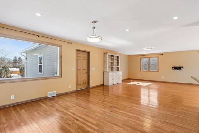 8209 N Port Washington Rd, Fox Point, WI 53217 - unfurnished living room featuring light wood finished floors, baseboards, visible vents, and recessed lighting