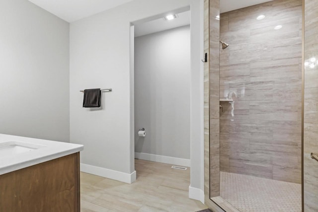 bathroom with vanity and a tile shower