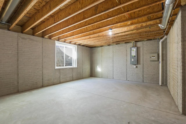 basement with brick wall and electric panel