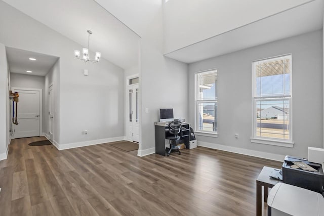 office featuring dark wood-type flooring, an inviting chandelier, and high vaulted ceiling