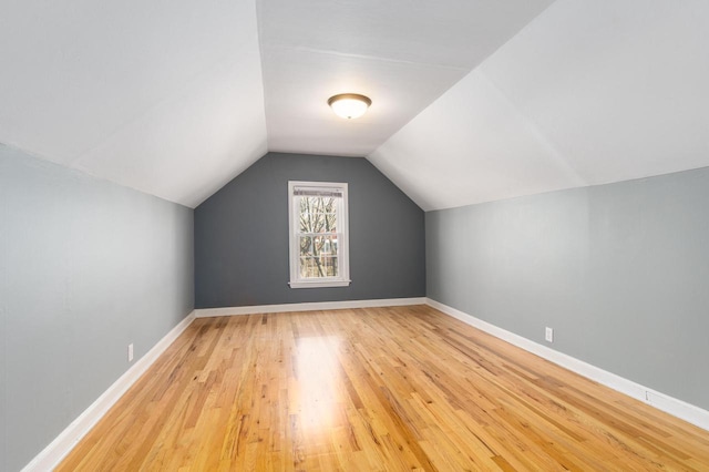 bonus room with vaulted ceiling and light hardwood / wood-style flooring