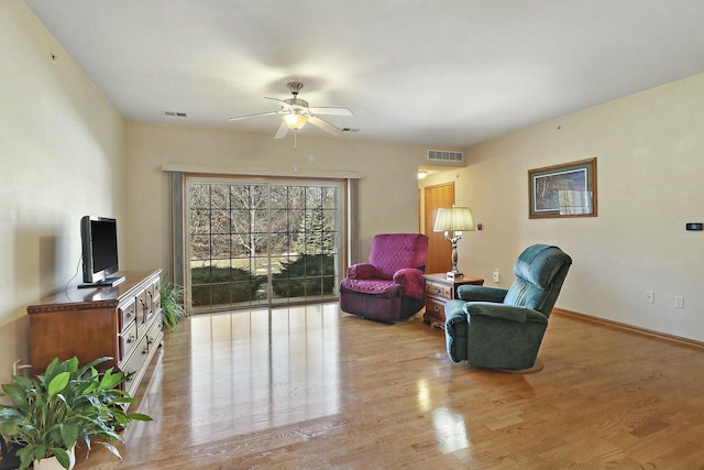 living area with light hardwood / wood-style floors and ceiling fan