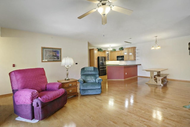 living room featuring ceiling fan and light hardwood / wood-style floors