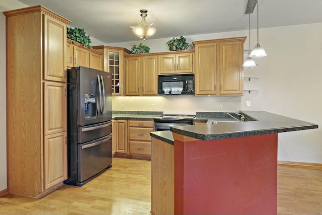 kitchen featuring stainless steel appliances, decorative light fixtures, sink, and light wood-type flooring