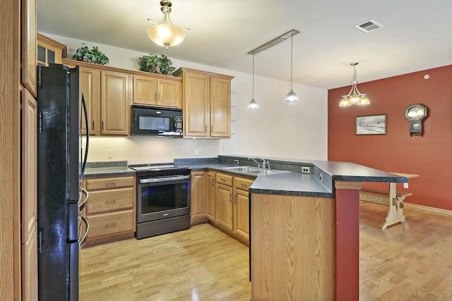 kitchen featuring black appliances, sink, a kitchen bar, hanging light fixtures, and kitchen peninsula