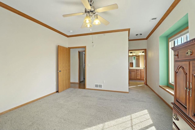 unfurnished bedroom with crown molding, ensuite bath, ceiling fan, and light carpet