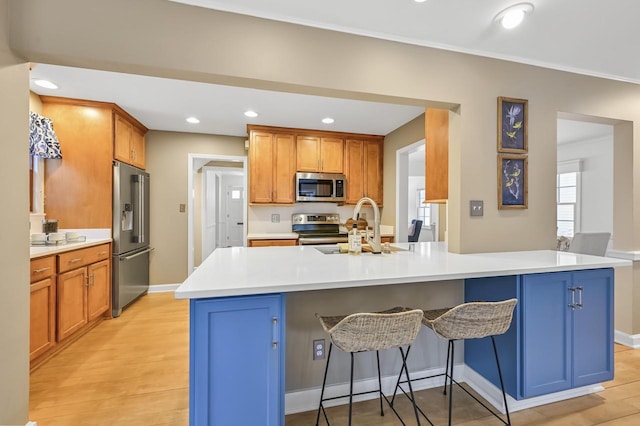 kitchen featuring stainless steel appliances, a center island, sink, and a kitchen breakfast bar