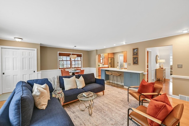 living room featuring sink and light hardwood / wood-style flooring