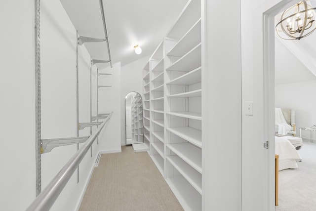 spacious closet with light carpet and a chandelier