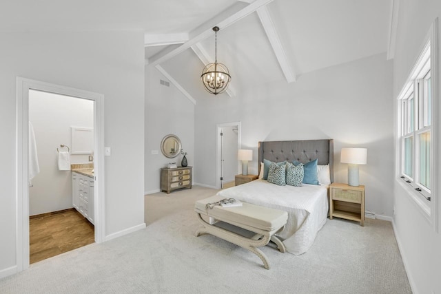 carpeted bedroom with an inviting chandelier, beam ceiling, ensuite bath, and high vaulted ceiling