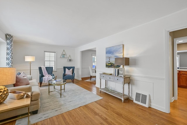 living room with ornamental molding and light wood-type flooring