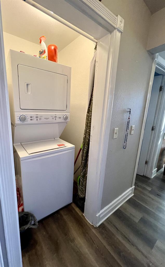 202 N Wisconsin Ave, Muscoda, WI 53573 - laundry room featuring stacked washer and clothes dryer and dark hardwood / wood-style flooring