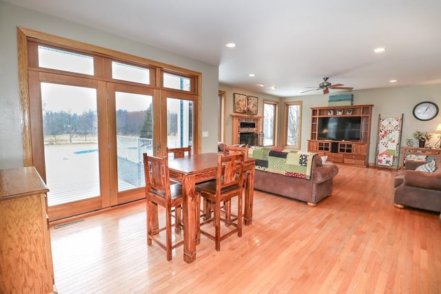 dining space with ceiling fan and light hardwood / wood-style floors