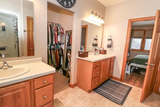 bathroom featuring vanity, tile patterned flooring, and a shower