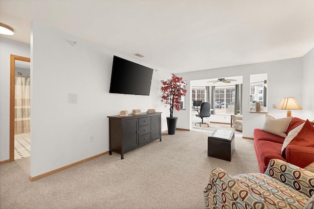 carpeted living room with ceiling fan