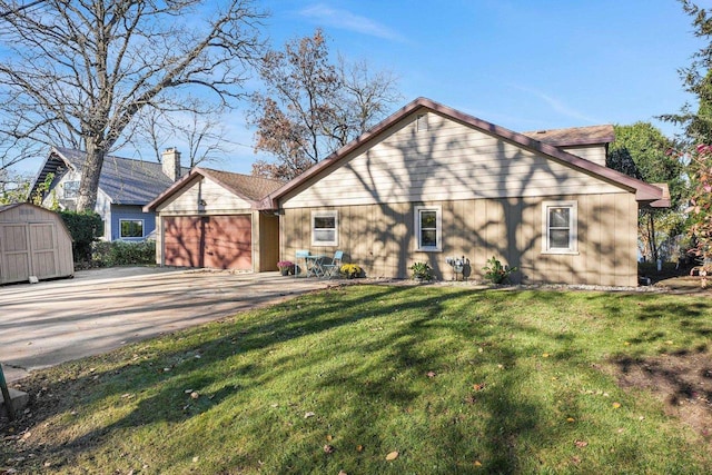 rear view of property with a garage and a lawn