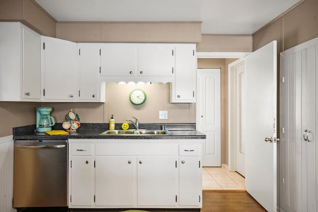 kitchen featuring sink, light tile patterned floors, white cabinets, and dishwasher