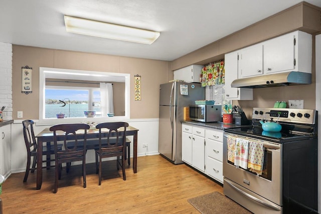 kitchen featuring a water view, appliances with stainless steel finishes, light hardwood / wood-style flooring, and white cabinets