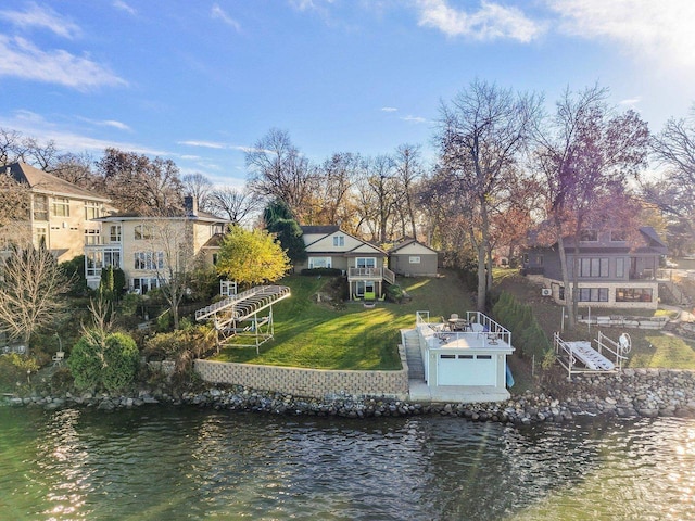 back of house featuring a yard and a water view