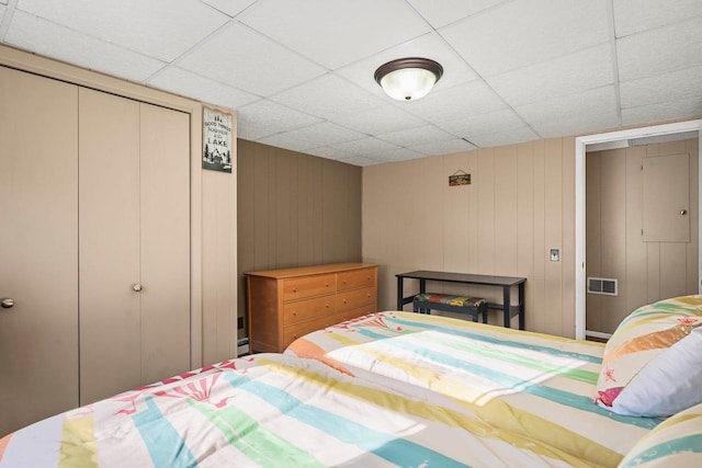 bedroom with a drop ceiling and a closet