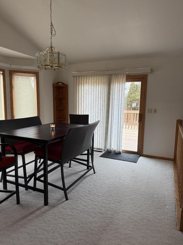 carpeted dining space with vaulted ceiling