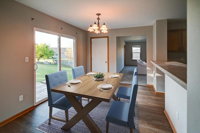 dining space with plenty of natural light, dark hardwood / wood-style floors, and a chandelier