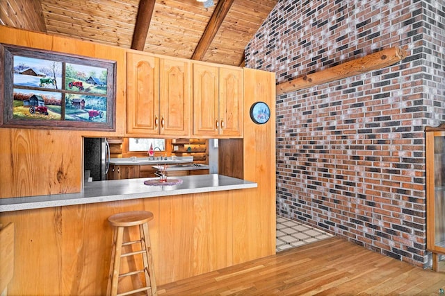 kitchen featuring wood ceiling, stainless steel refrigerator, vaulted ceiling with beams, hardwood / wood-style floors, and brick wall