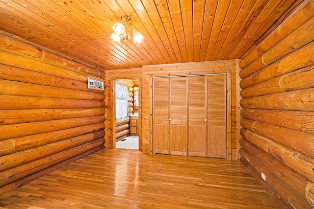 unfurnished bedroom with wood ceiling, light hardwood / wood-style flooring, and log walls