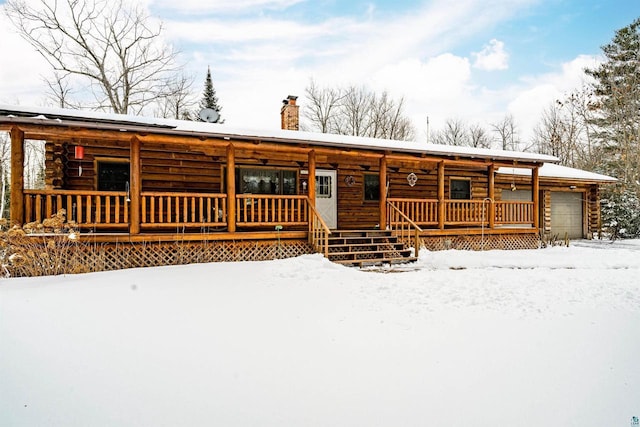 log-style house with a garage and covered porch