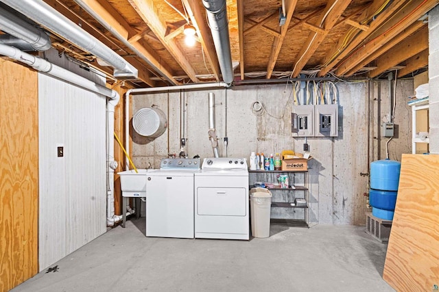 laundry area featuring electric panel, washer and clothes dryer, and sink