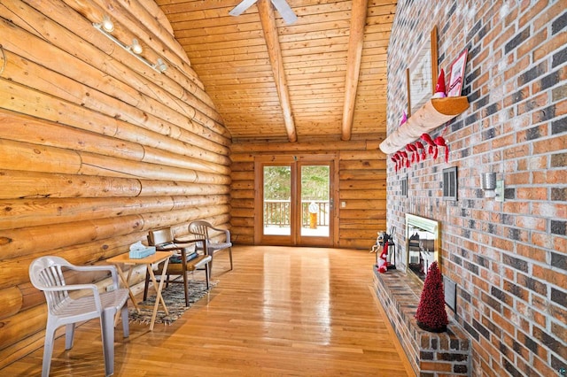 unfurnished room featuring hardwood / wood-style floors, beam ceiling, a fireplace, log walls, and wooden ceiling