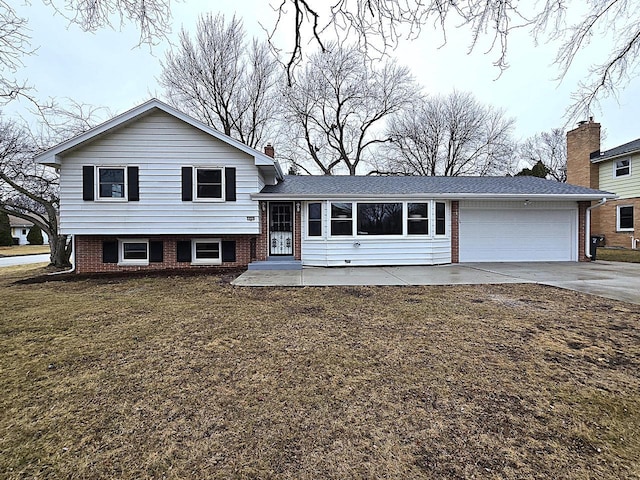 tri-level home with a garage and a front yard