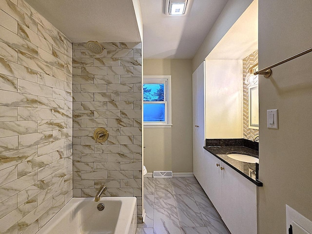 bathroom with tiled shower / bath and vanity