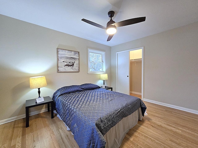 bedroom with ceiling fan, light wood-type flooring, and a closet