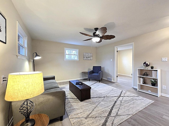 living room with wood-type flooring and ceiling fan