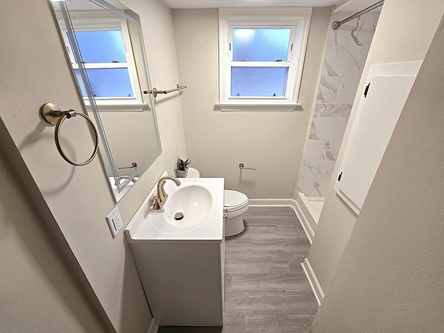 bathroom with hardwood / wood-style flooring, vanity, toilet, and a shower